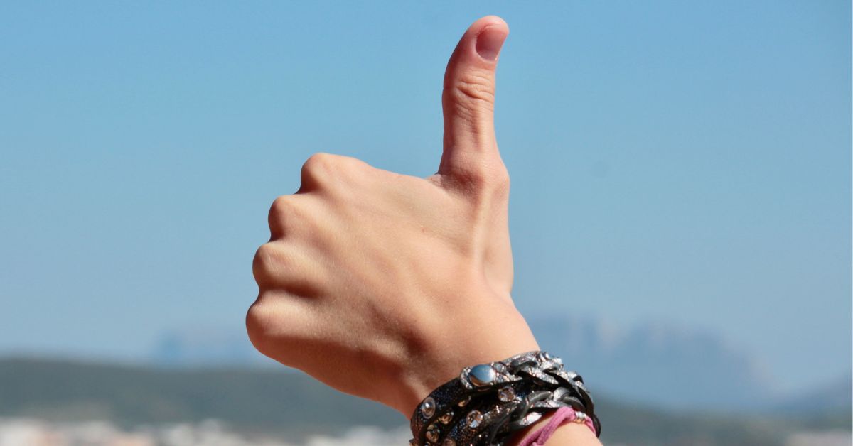A person holding up a "thumbs up" signal as the cover image for the blog article, "Is Delta 9 Safe? is it Regular THC?