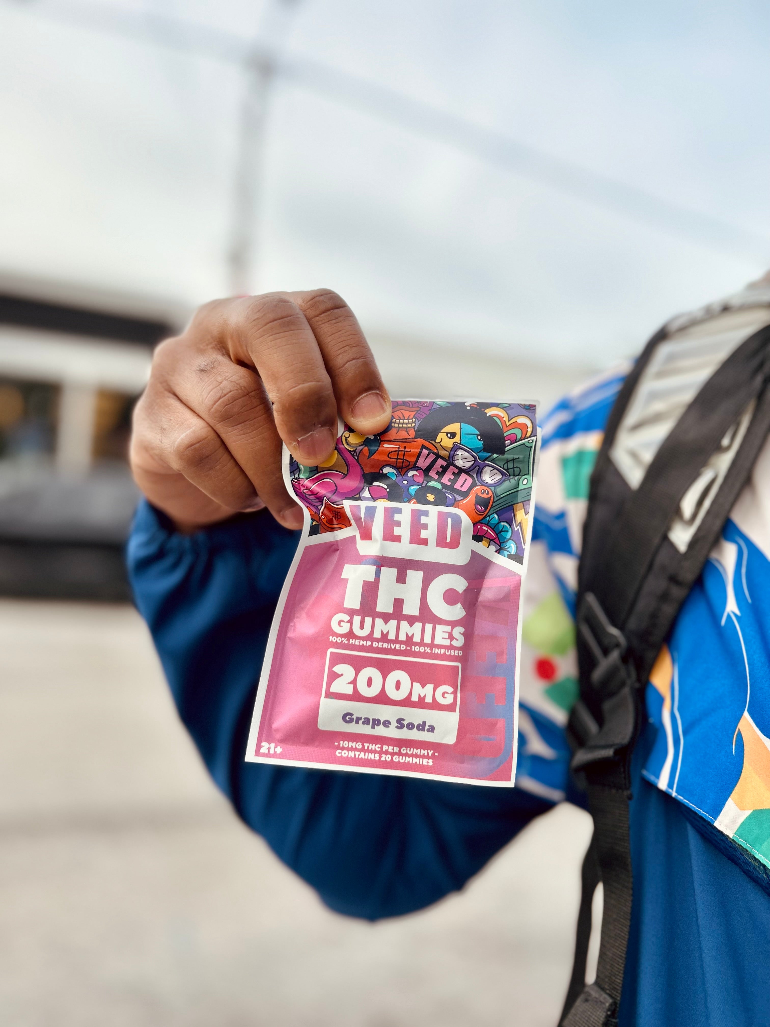 Person holding a VEED THC gummy bag outdoors, highlighting cannabis edibles for mindful enjoyment