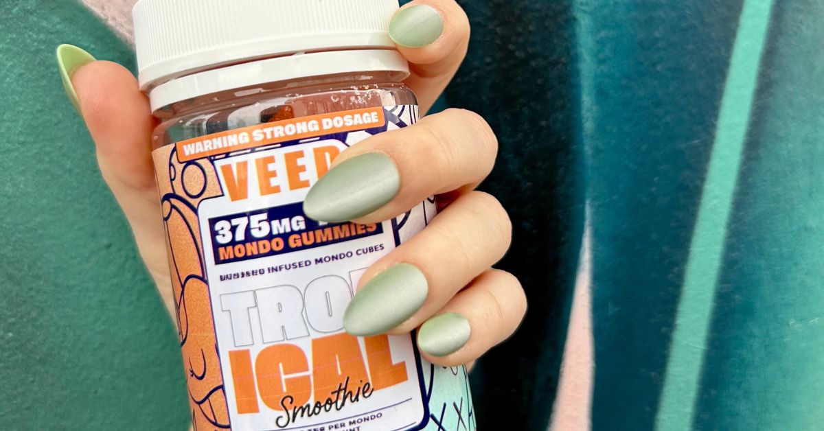 Hand holding a container of VEED Labs THC gummies 25mg